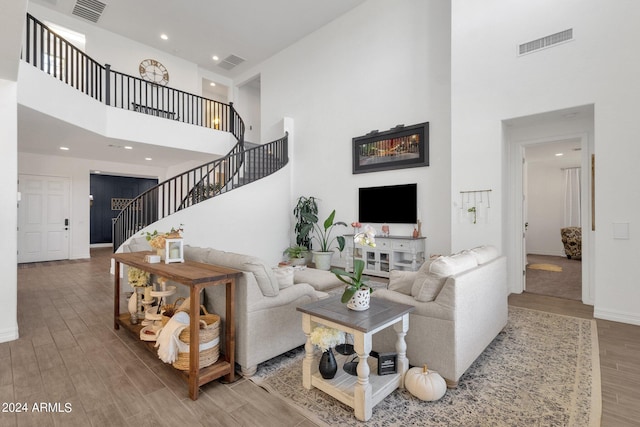 living room featuring a high ceiling and hardwood / wood-style flooring