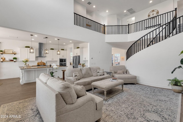 living room with a towering ceiling and hardwood / wood-style flooring