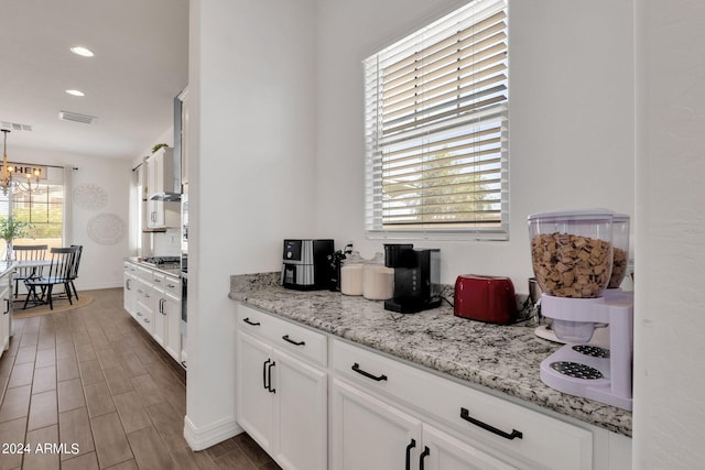 kitchen featuring dark hardwood / wood-style flooring, white cabinetry, and a healthy amount of sunlight