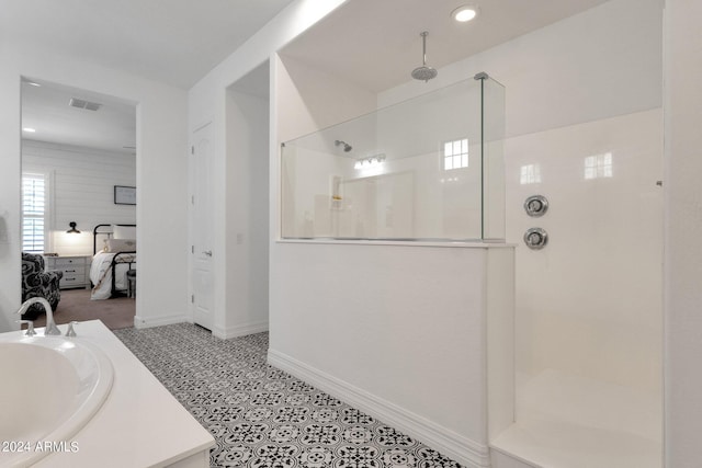 bathroom with a tile shower and sink