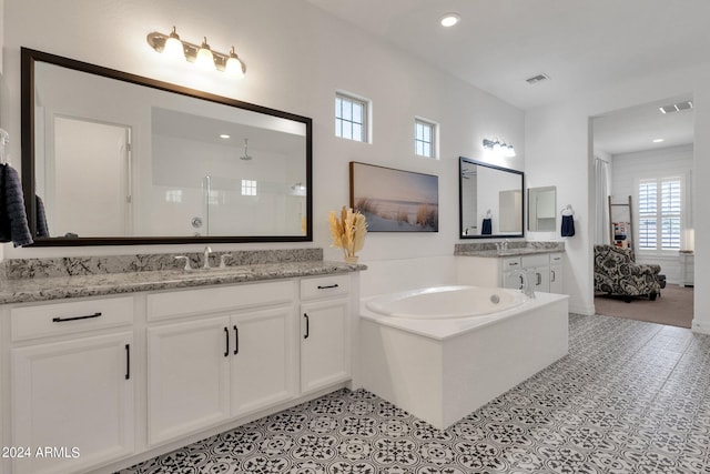 bathroom featuring tile patterned floors, vanity, and a tub