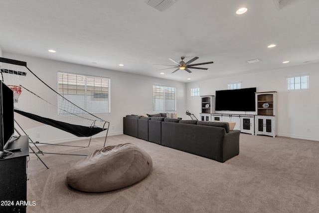 living room featuring ceiling fan, a healthy amount of sunlight, and light colored carpet