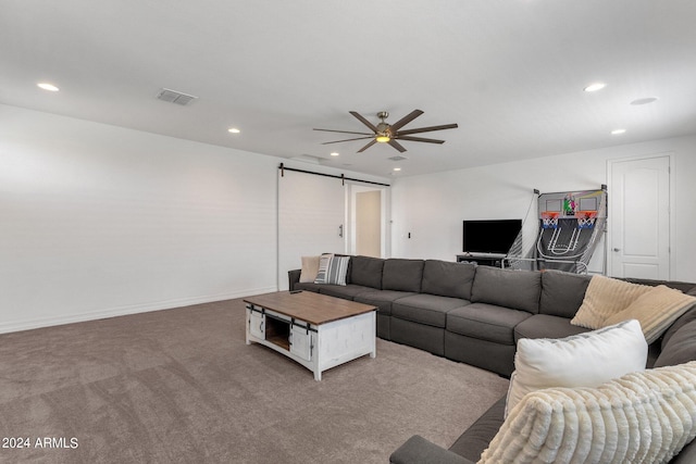 living room featuring light carpet, a barn door, and ceiling fan