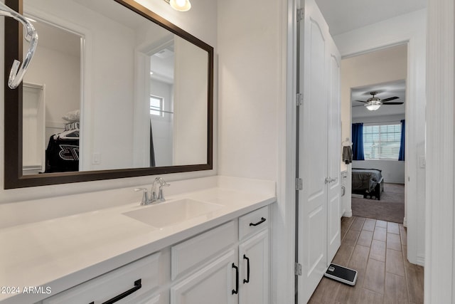 bathroom with hardwood / wood-style floors, vanity, and ceiling fan