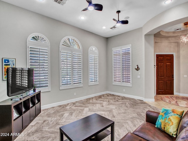 living room with ceiling fan, light parquet floors, and plenty of natural light