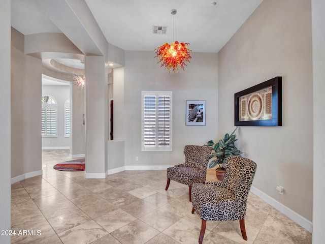 sitting room featuring a chandelier and a healthy amount of sunlight