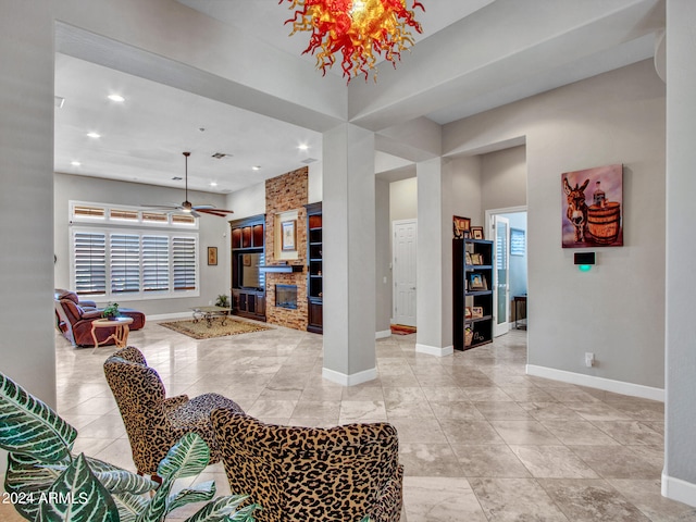 interior space with ceiling fan, a stone fireplace, and a healthy amount of sunlight