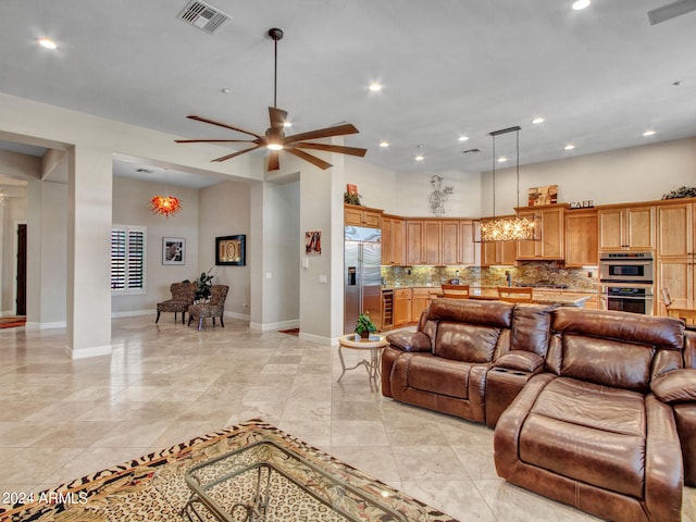 tiled living room featuring ceiling fan with notable chandelier