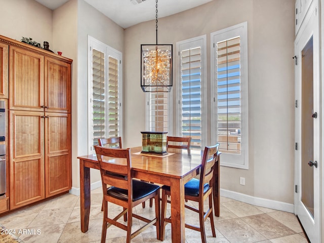 dining space with light tile patterned floors and a notable chandelier