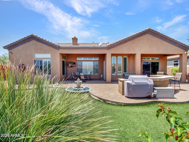 rear view of property featuring a yard and a patio