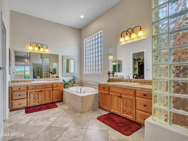 bathroom featuring vanity, tiled bath, tile patterned flooring, and a high ceiling