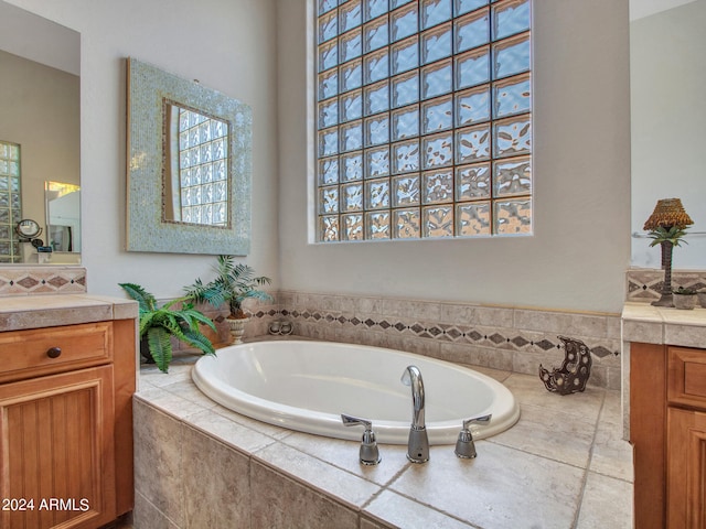 bathroom featuring vanity and a relaxing tiled tub