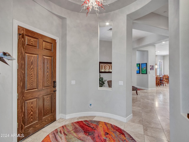 tiled foyer with a notable chandelier