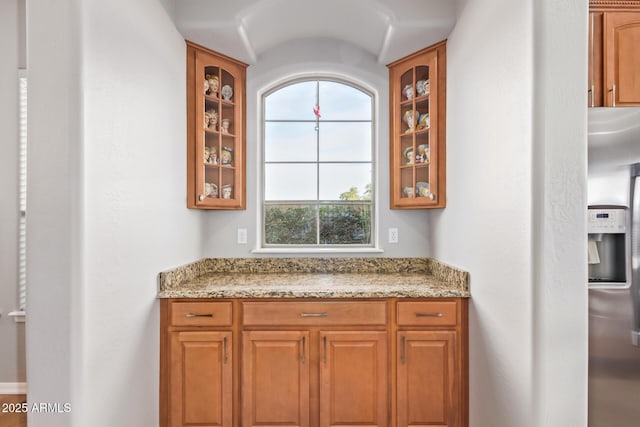 kitchen featuring stainless steel fridge and light stone counters