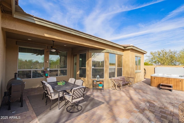 view of patio featuring ceiling fan and a hot tub