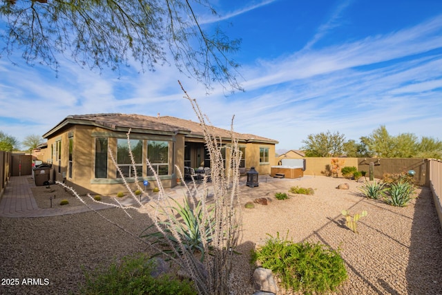 back of house with a patio area and a hot tub