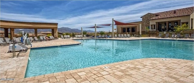 view of swimming pool featuring a mountain view and a patio