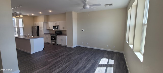 kitchen with stainless steel appliances, visible vents, dark wood-type flooring, white cabinets, and baseboards