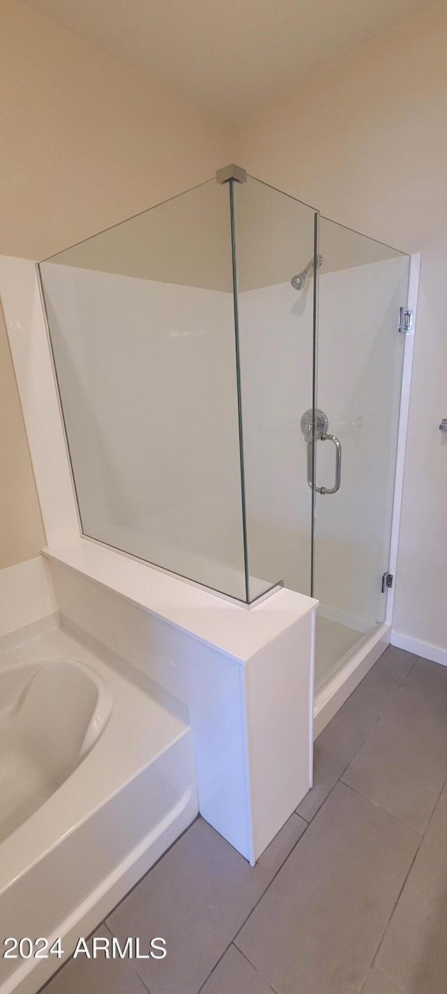 full bathroom with a stall shower, tile patterned flooring, and a garden tub