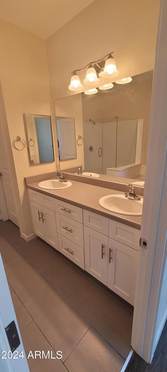 bathroom with double vanity, a sink, and tile patterned floors