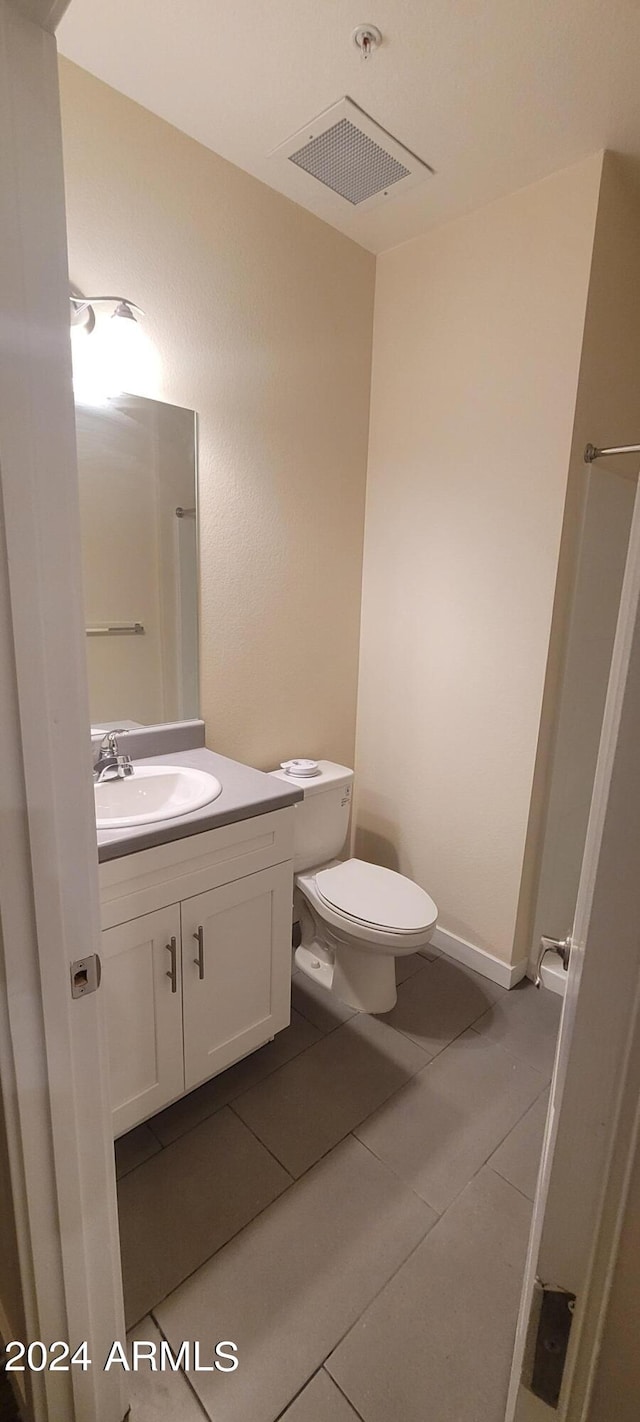 bathroom with toilet, tile patterned floors, visible vents, and vanity