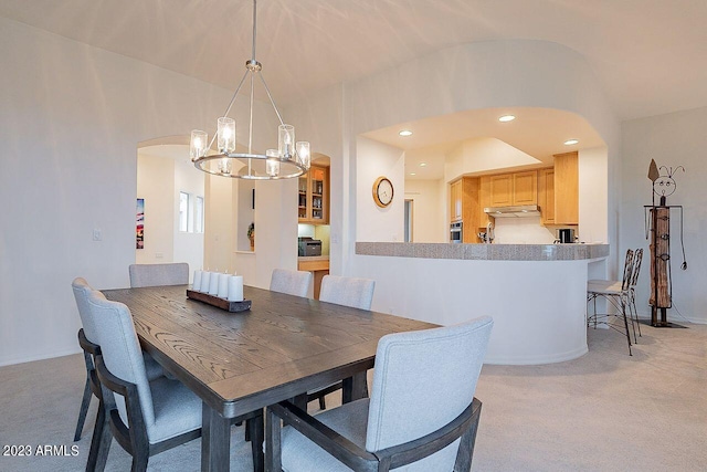 dining area with a notable chandelier and light carpet