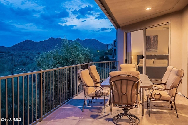 balcony at dusk featuring a mountain view