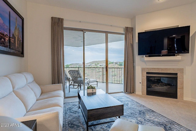 carpeted living room with a tiled fireplace