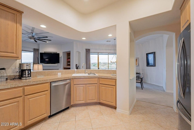 kitchen with ceiling fan, dishwasher, sink, black refrigerator, and light brown cabinetry