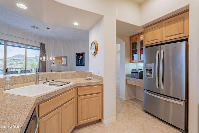 kitchen featuring appliances with stainless steel finishes, sink, light tile patterned floors, pendant lighting, and a notable chandelier