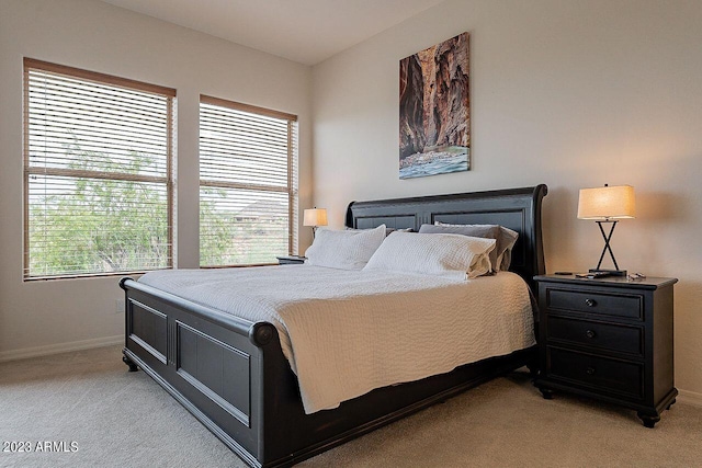 bedroom with light carpet and multiple windows