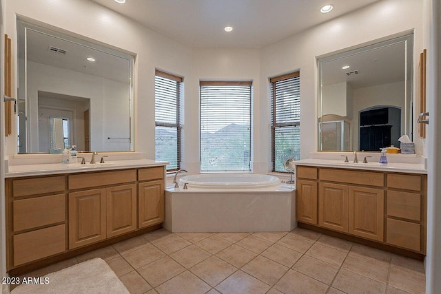 bathroom with a bathing tub, tile patterned flooring, and vanity