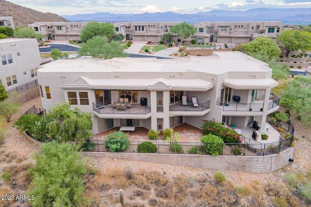 rear view of property featuring a mountain view and a balcony