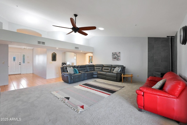 tiled living room with ceiling fan with notable chandelier and vaulted ceiling