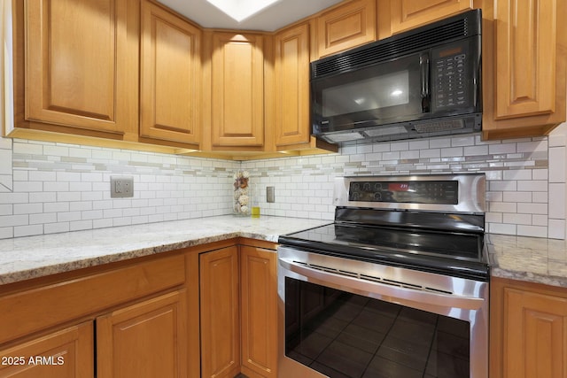 kitchen featuring light stone countertops, backsplash, and electric stove