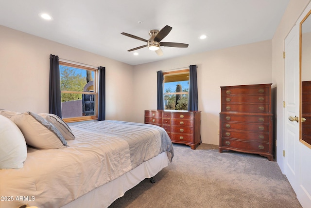 bedroom with multiple windows, ceiling fan, and carpet