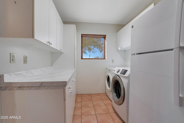 laundry area with light tile patterned flooring, cabinets, and washing machine and clothes dryer