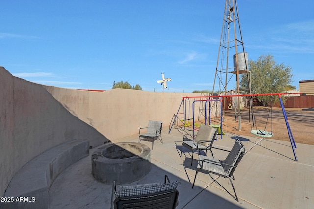 view of patio / terrace with a playground and a fire pit