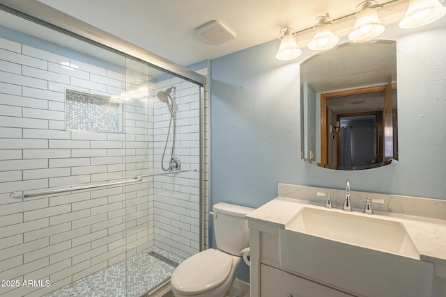 full bathroom with visible vents, vanity, a shower stall, and toilet