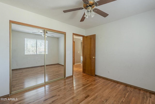 unfurnished bedroom featuring baseboards, light wood-style flooring, a ceiling fan, and a closet