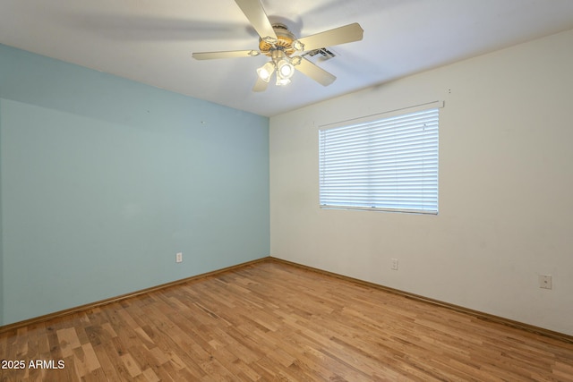 empty room featuring light wood-style floors, visible vents, and a ceiling fan