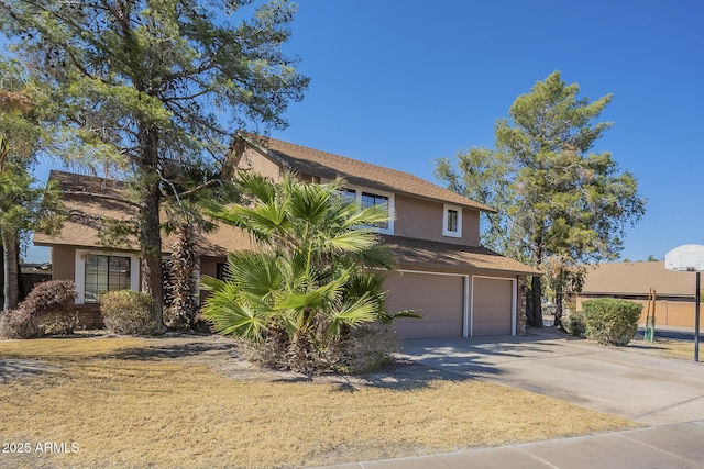 view of front of home with driveway, an attached garage, and stucco siding