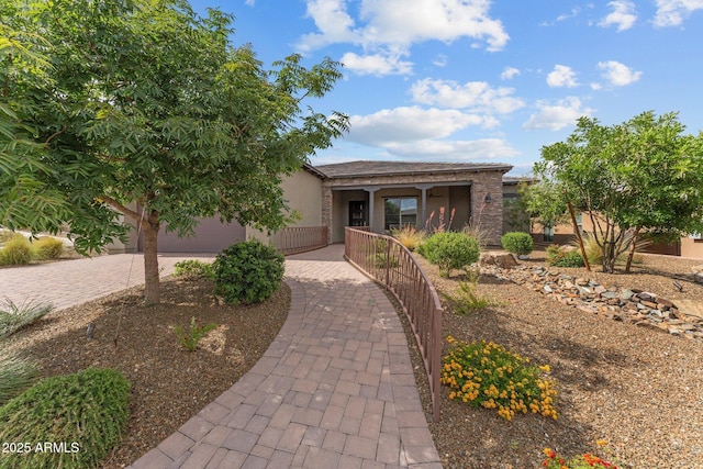view of front facade with stucco siding and decorative driveway
