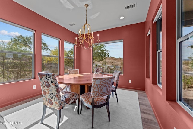 dining room with baseboards, a notable chandelier, visible vents, and wood finished floors