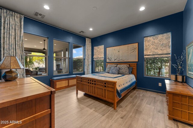 bedroom with multiple windows, visible vents, and wood finished floors