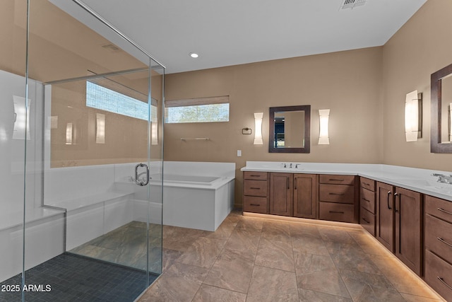 full bath featuring a stall shower, a garden tub, double vanity, and a sink