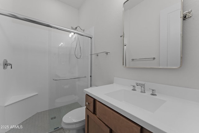 bathroom featuring vanity, toilet, and a shower stall