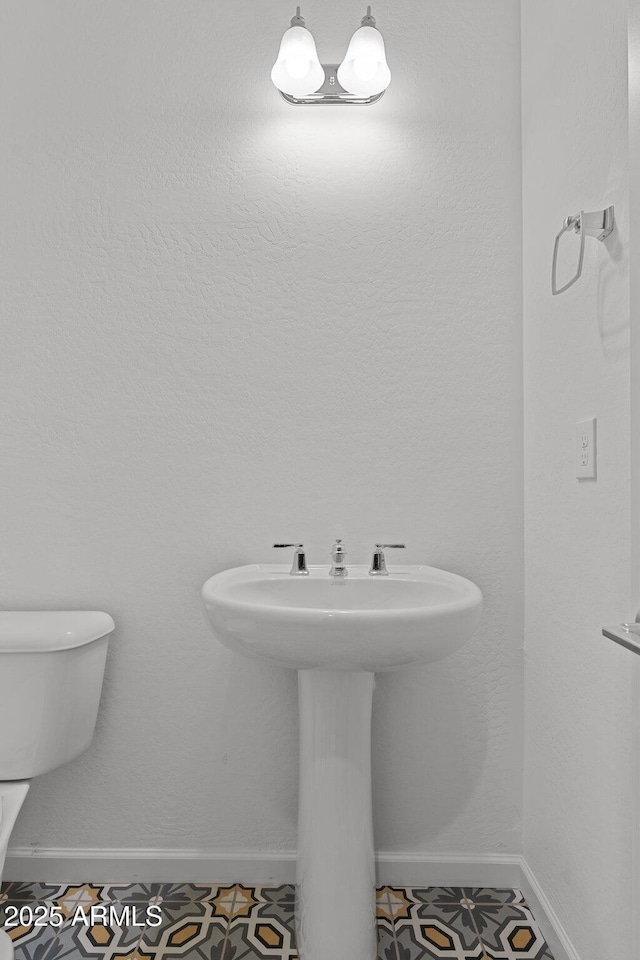 bathroom featuring toilet and baseboards