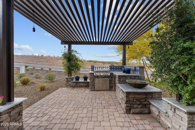 view of patio with an outdoor kitchen, a pergola, and grilling area