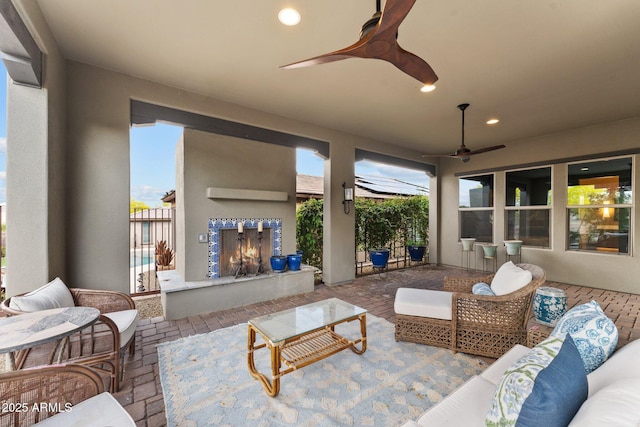 view of patio featuring an outdoor living space with a fireplace and a ceiling fan